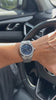 William Corbier RIDGE Dark Azure customer video: blue dial steel watch on a wrist at a car steering wheel