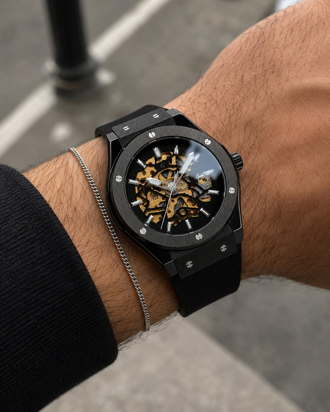 Image of William Corbier MACH Onyx men's automatic skeleton watch, worn on a wrist with a silver chain bracelet