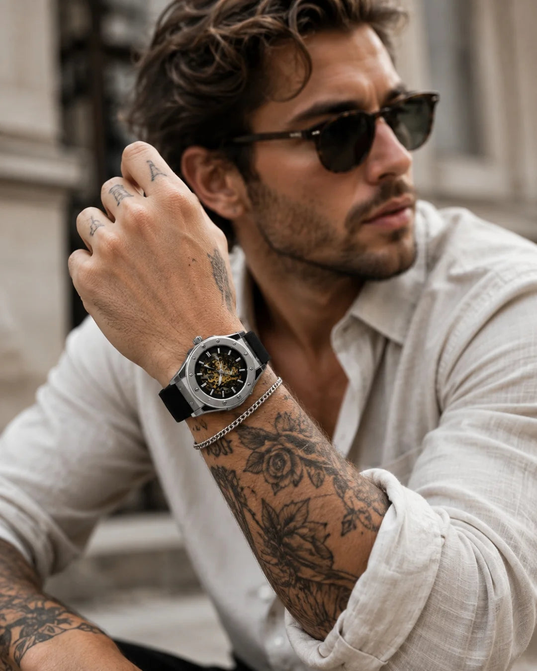 Image of Man with sunglasses and tattoos in a white shirt wearing the William Corbier MACH Silver Mist men's automatic skeleton watch