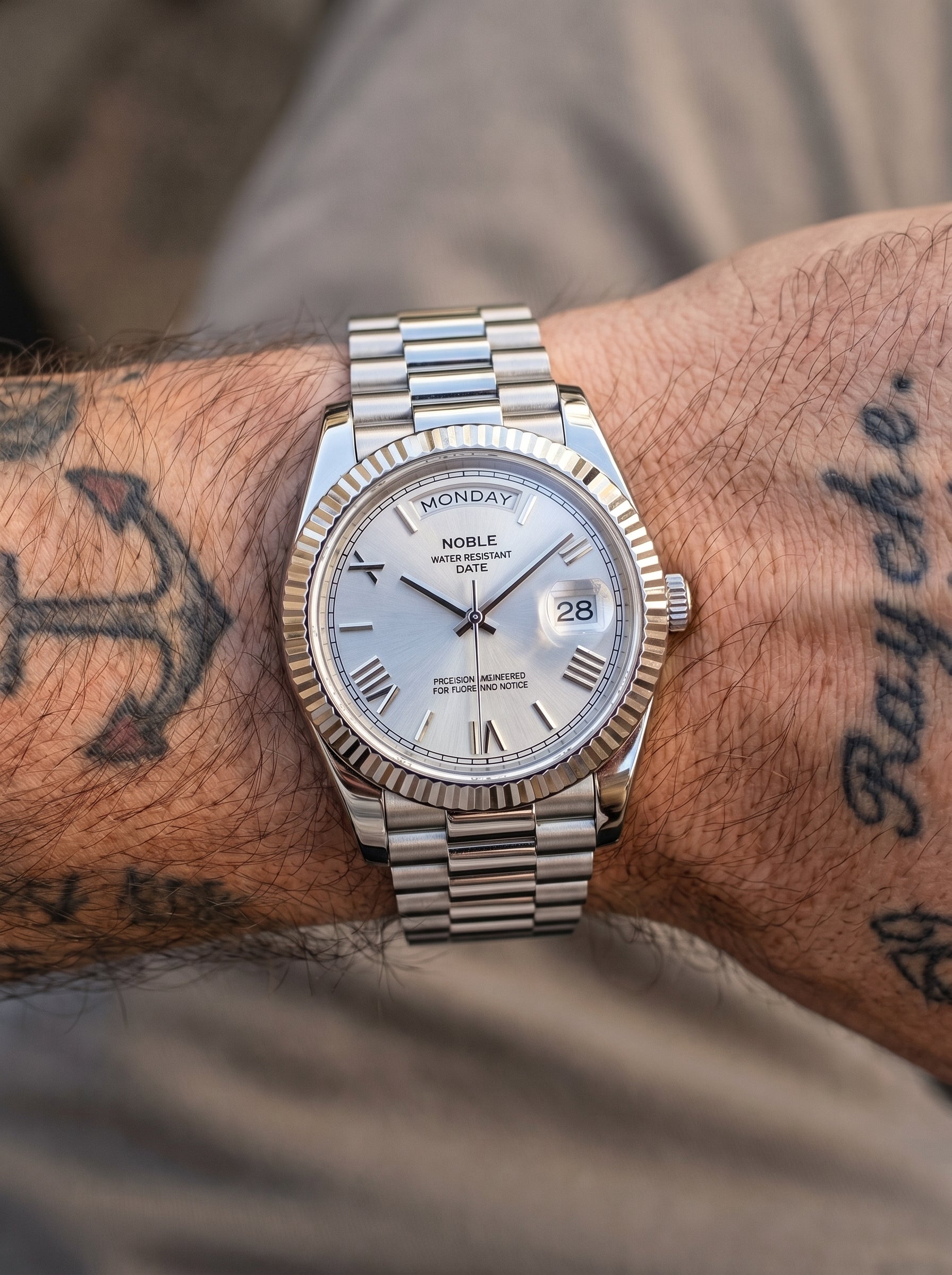 Image of William Corbier NOBLE Alpine men's white dial day-date watch, worn on a tattooed wrist