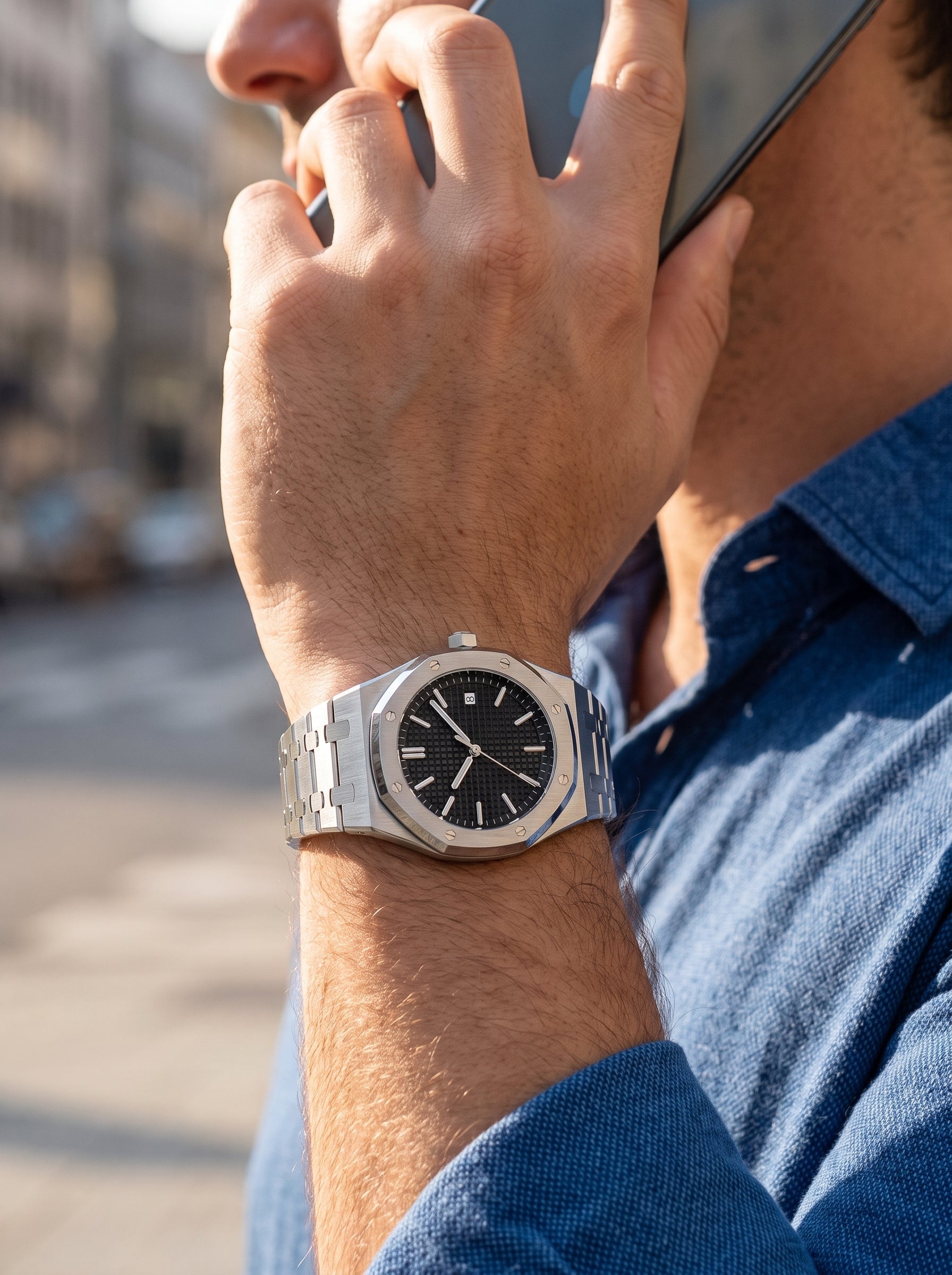 Image of Man in a blue shirt on a phone call wearing the William Corbier RIDGE Obsidian men's black dial steel watch