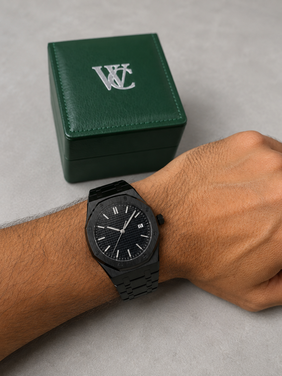 Image of William Corbier RIDGE Onyx men's black dial steel watch, worn on a wrist beside a closed green gift box