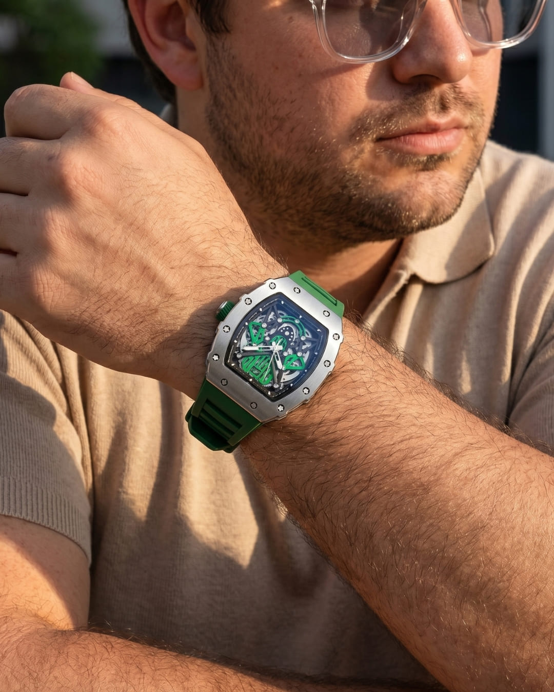 Man in a beige polo and glasses with crossed arms wearing the William Corbier SURGE Emerald men's automatic skeleton watch